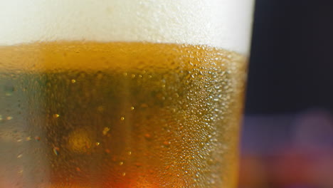Close-up-slow-motion:-cold-Beer-in-a-glass-large-drops-and-bubbles-in-the-beer